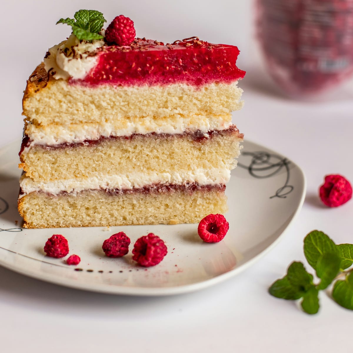 Stück Biskuittorte mit Himbeeren auf einem Teller